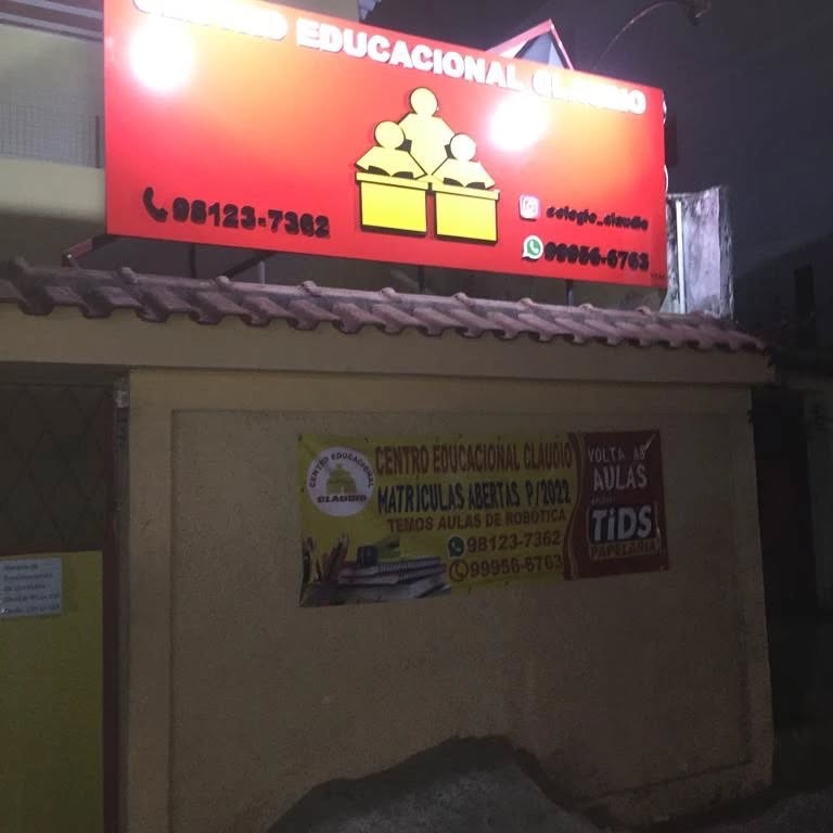 Fachada do Centro Educacional Claudio à noite, com o letreiro vermelho aceso