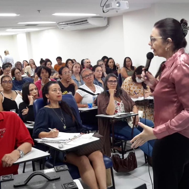 Professoras assistindo a uma palestra sobre inclusão em um auditório